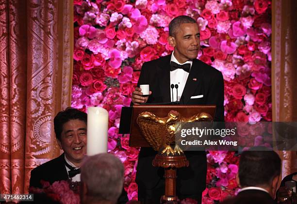 President Barack Obama and Japanese Prime Minister Shinzo Abe participate in a toast with sake during a state dinner at the East Room of the White...