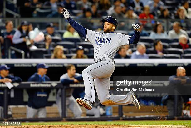 James Loney of the Tampa Bay Rays slides home with a run in the sixth inning against the New York Yankees after a triple from teammate Logan Forsythe...