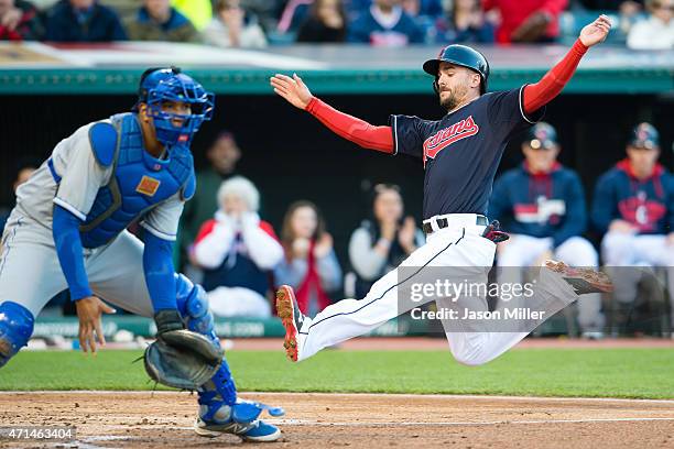 Catcher Salvador Perez of the Kansas City Royals waits for the throw as Lonnie Chisenhall of the Cleveland Indians is safe at home on a hit from...