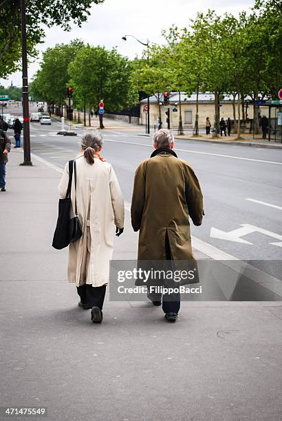 elderly couple walking - trench coat back stock pictures, royalty-free photos & images