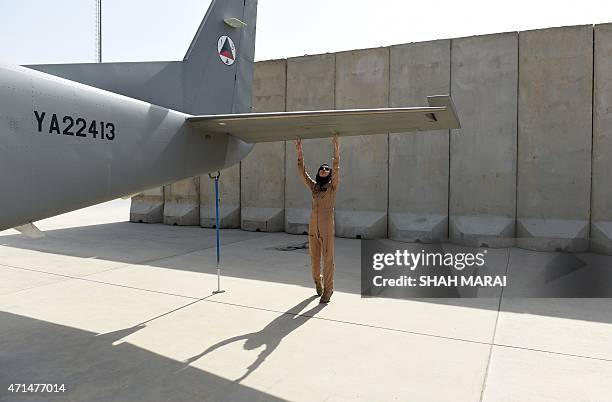 In a picture taken on April 26 Afghanistan's first female pilot Niloofar Rahmani examines a fixed-wing Afghan Air Force aviator aircraft in Kabul....