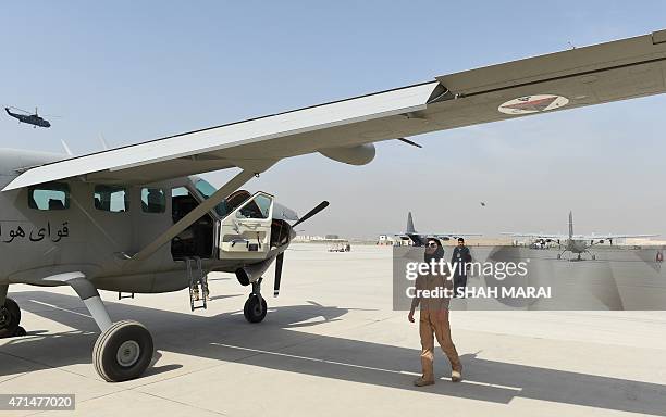 In a picture taken on April 26 Afghanistan's first female pilot Niloofar Rahmani examines a fixed-wing Afghan Air Force aviator aircraft in Kabul....