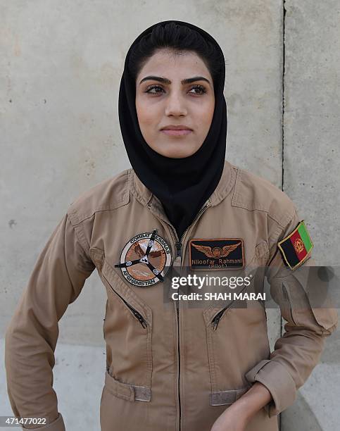 In a picture taken on April 26 Afghanistan's first female pilot Niloofar Rahmani looks on as she talks with colleagues at an airfield in Kabul. With...