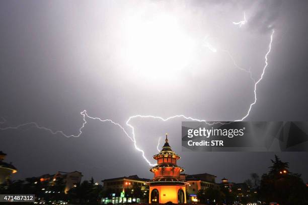 This picture taken on April 28, 2015 shows lightning brightening the sky over a pagoda in Yangzhou, east China's Jiangsu province. CHINA OUT AFP PHOTO