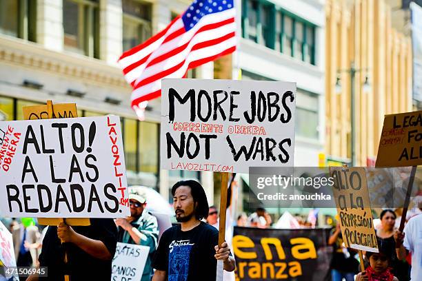 homme dans une foule tenant affiche au cours du mois de mars pourront jour - may day protest in los angeles photos et images de collection