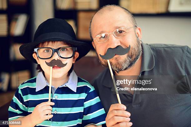 vater und ihren kleinen sohn - movember stock-fotos und bilder