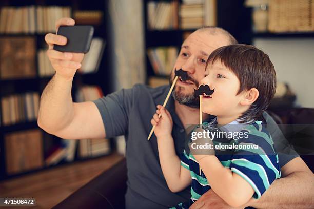 father and little son - movember moustache stock pictures, royalty-free photos & images