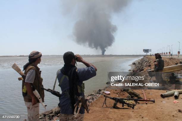 Smoke billows on the horizon as supporters of exiled Yemeni President Abedrabbo Mansour Hadi block a road in al-Mansura, east of the southern Yemeni...