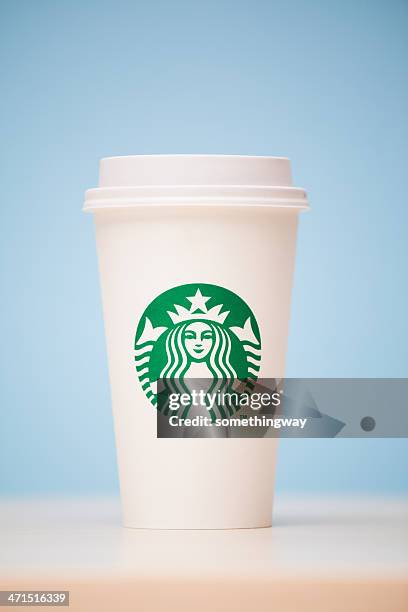 grande starbucks to go cup on table - starbucks coffee stock pictures, royalty-free photos & images