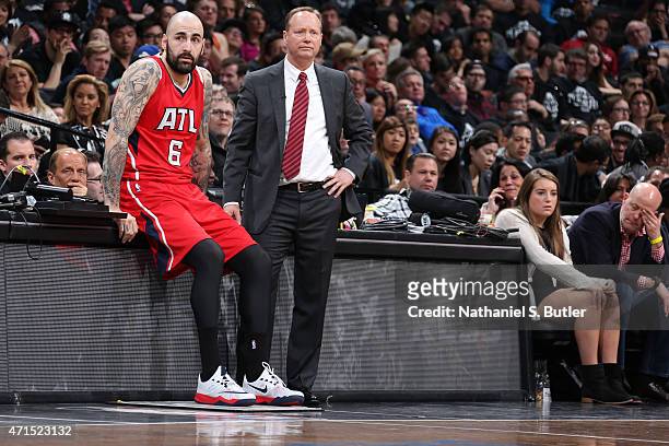 Pero Antic and Mike Budenholzer of the Atlanta Hawks talk during Game Three of the Eastern Conference Quarterfinals against the Brooklyn Nets during...
