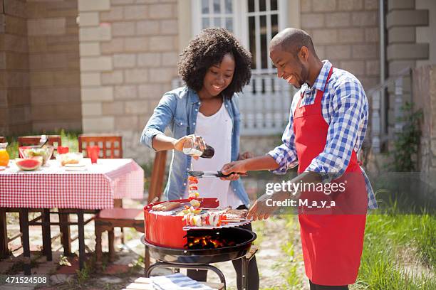 two people barbecuing on the grill - burgers cooking grill stockfoto's en -beelden