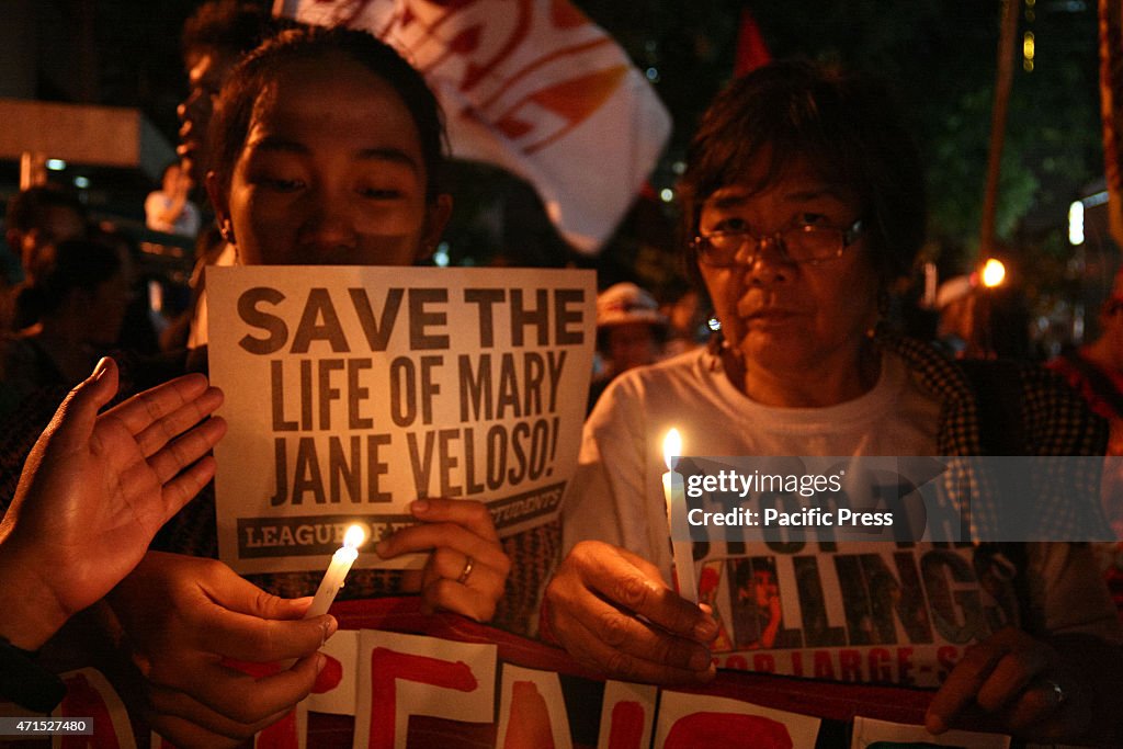 Protesters hold up candles in front of the Indonesian...