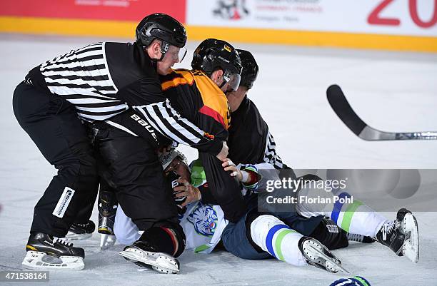 Linesman Nikolaj Ponomarjow, Patrick Hager of Team Germany and Rok Ticar of Team Slovenia during the game between Germany and Slovenia on april 29,...