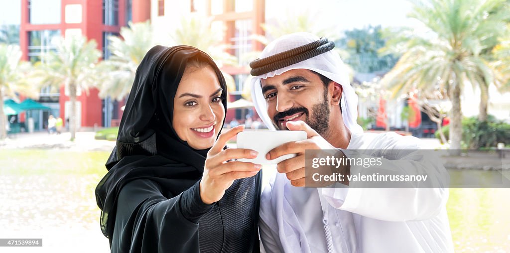 Middle Eastern family take a selfie using mobile phone