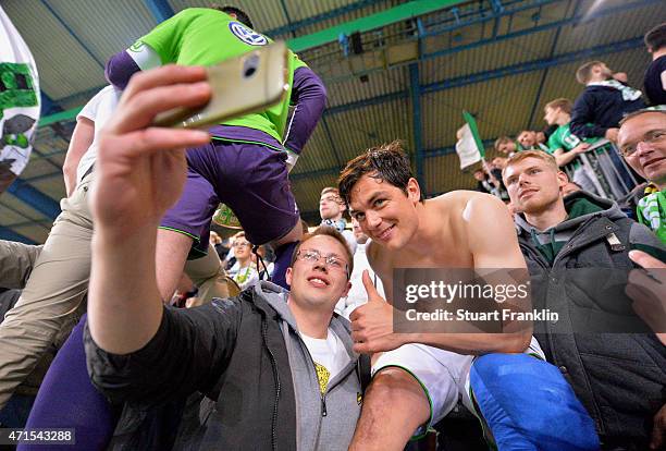 Fan of Wolfsburg takes a selfie with Marcel Schaefer of Wolfsburg after the DFB Cup Semi Final match between Arminia Bielefeld and VfL Wolfsburg at...