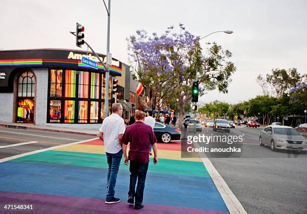 two men crossing street colored as rainbow gay flag - west hollywood california stock pictures, royalty-free photos & images