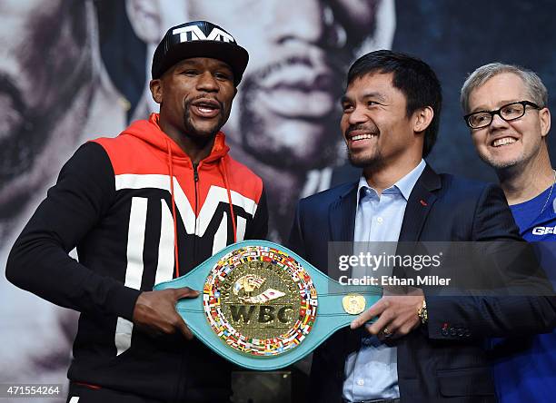 Welterweight champion Floyd Mayweather Jr. And WBO welterweight champion Manny Pacquiao pose with a WBC championship belt as Pacquiao's trainer...