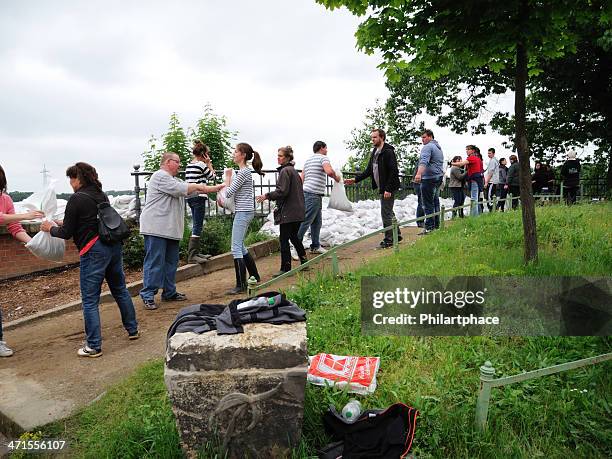 freiwillige helfer stapeln sandsäcke - sandbag stock-fotos und bilder