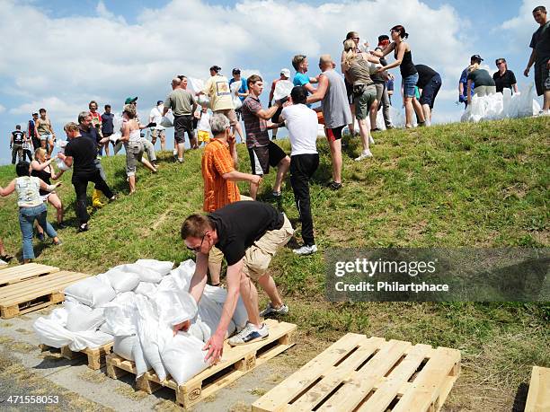 people fighting flood water - sandbag stock pictures, royalty-free photos & images