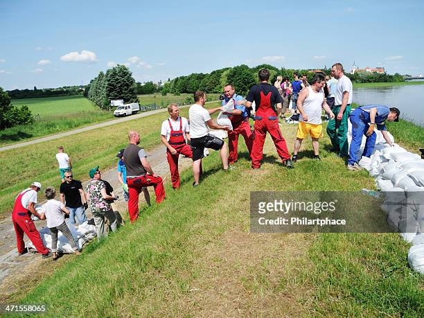 people fighting flood water - sandbag stock pictures, royalty-free photos & images