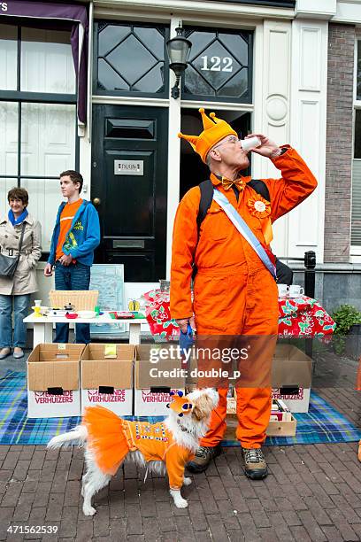 man and dog - kings day celebration in amsterdam stock pictures, royalty-free photos & images