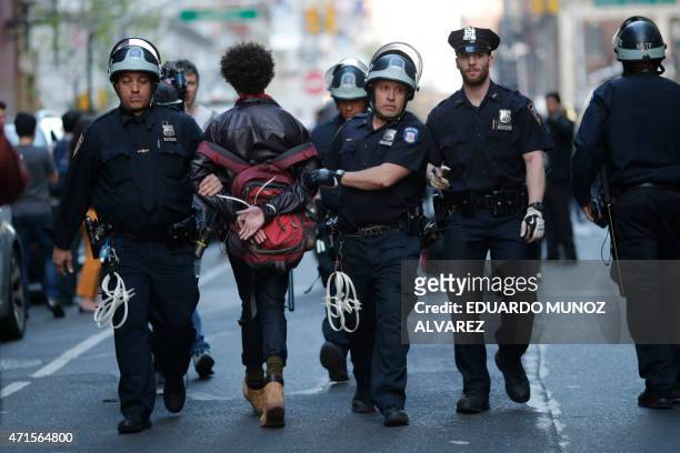 Demonstrator is arrested by police officers during a protest April 29, 2015 at Union Square in New York, held in solidarity with demonstrators in...