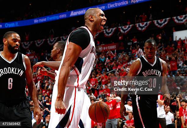 Al Horford of the Atlanta Hawks reacts after scoring a basket against Alan Anderson and Thaddeus Young of the Brooklyn Nets during Game Five of the...