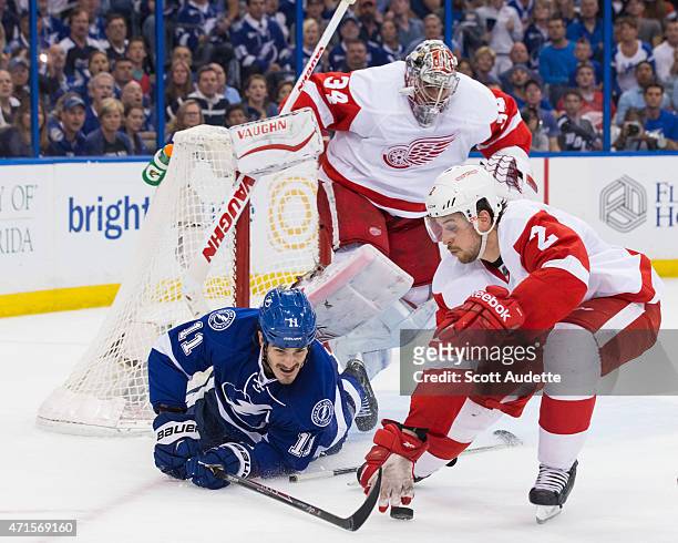 Brian Boyle of the Tampa Bay Lightning battles for the puck against Brendan Smith of the Detroit Red Wings after sliding into goalie Petr Mrazek...