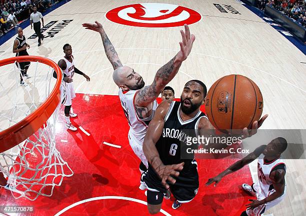 Alan Anderson of the Brooklyn Nets drives against Pero Antic and Paul Millsap of the Atlanta Hawks during Game Five of the Eastern Conference...