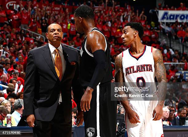 Jeff Teague of the Atlanta Hawks attempts to listen as Lionel Hollins of the Brooklyn Nets converses with Joe Johnson during Game Five of the Eastern...