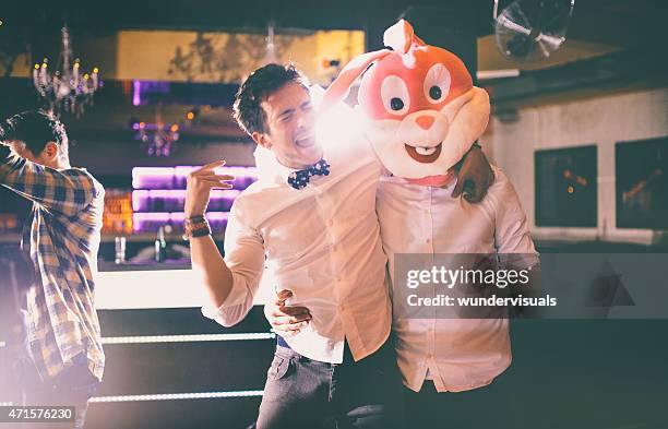 guy wearing bunny head with friend at party in club - crazy party stockfoto's en -beelden