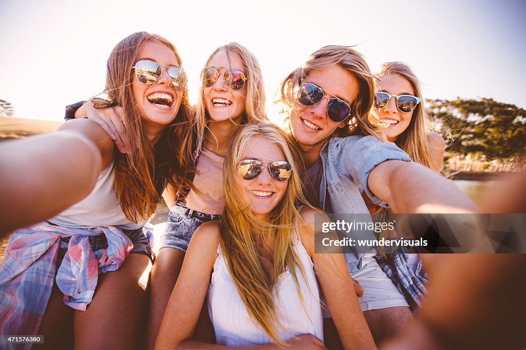 Adolescentes en tonos tomando un grupo autofoto al aire libre