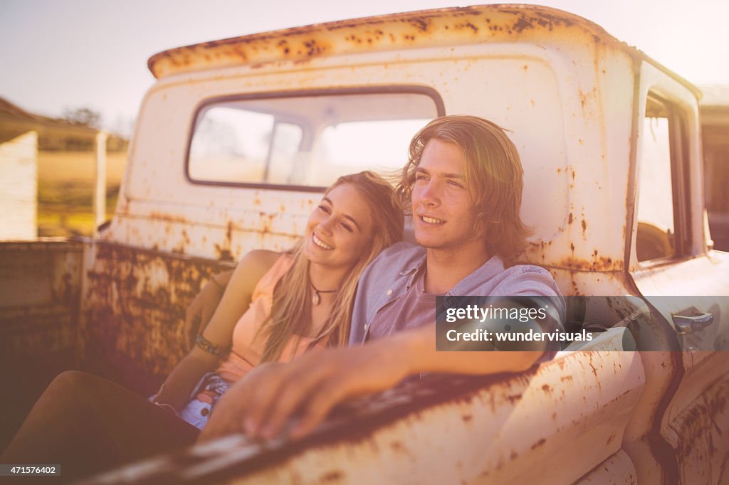 Teen paar sitzen zusammen in einem liebevoll vintage-truck