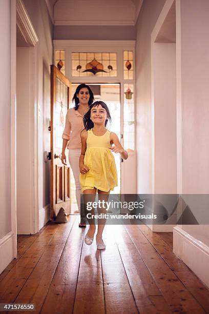 daughter running ahead of her mom into their new home - front door open stock pictures, royalty-free photos & images