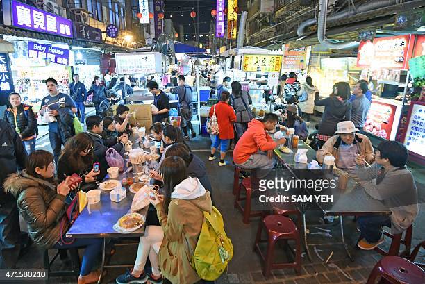 To go with Taiwan-food-lifestyle-design, FEATURE by Laura MANNERING In this photo taken on April 13 tourists and local residents eat food at the...