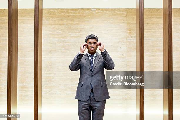 Tengku Zafrul Aziz, chief executive officer of CIMB Group Holdings Bhd., adjusts his glasses while posing for a portrait before an interview in Kuala...