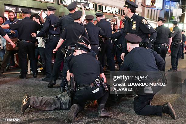 Demonstrator is arrested by NYPD officers during a protest march through Times Square April 29, 2015 in New York, held in solidarity with...