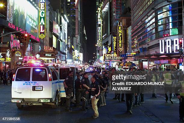 Officers stand guard while arresting some demonstrators during a protest march through Times Square April 29, 2015 in New York, held in solidarity...