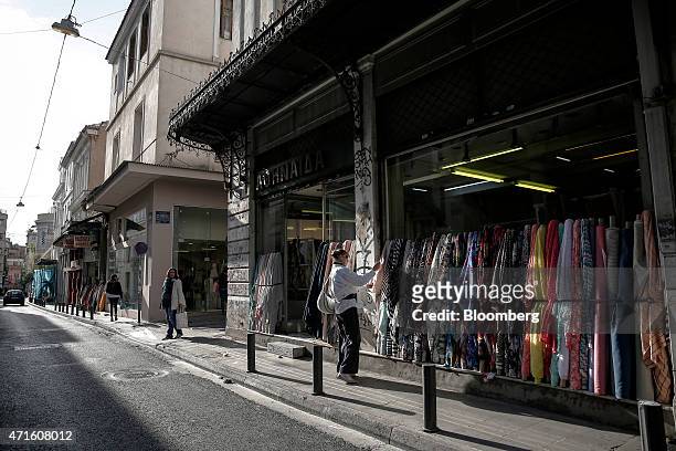 Woman looks at fabrics outside a fabric store in the Agia Irini district of Athens, Greece, on Saturday, April 25, 2015. The downturn that decimated...