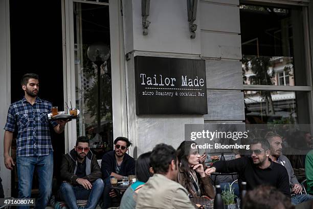 Waiter serves drinks at a cocktail bar, previously a fabric store, in the Agia Irini district of Athens, Greece, on Saturday, April 25, 2015. The...