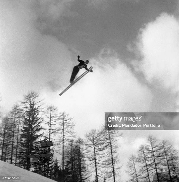 Skier competing in the VII Olympic Winter Games performing a jump. Cortina d'Ampezzo, 1956 "