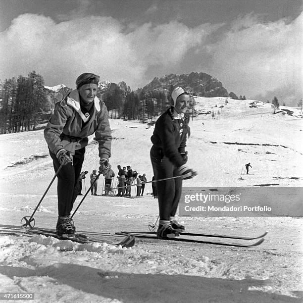 "Two Swiss skiers smiling on the ski slope during the VII Olympic Winter Games. Cortina d'Ampezzo, 1956 "