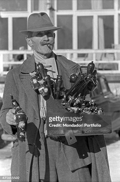 Pedlar selling pipes during the VII Olympic Winter Games. Cortina d'Ampezzo, 1956 "