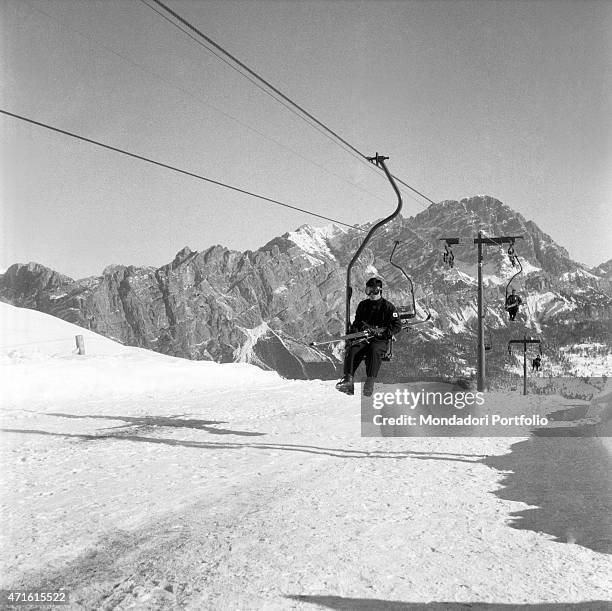 "Japanese alpine ski racer Chiharu Igaya going uphill on the chairlift during the VII Olympic Winter Games. Cortina d'Ampezzo, 1956 "