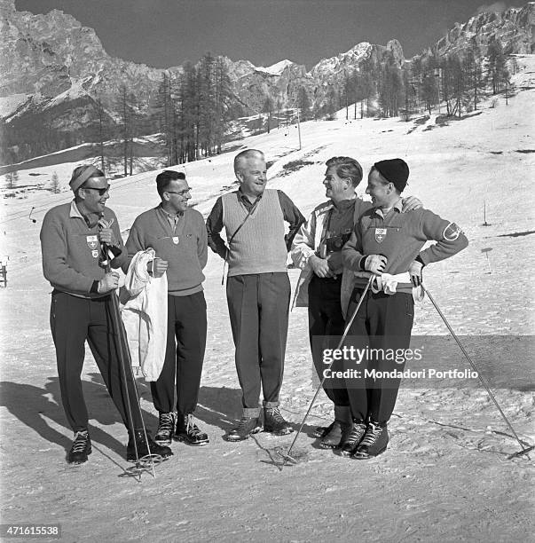 Group of Swiss alpine skiers joking on the ski slope in a break during the VII Olympic Winter Games. Cortina d'Ampezzo, 1956 "