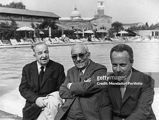 "Italian publisher Arnoldo Mondadori and Italian writers and poets Giorgio Bassani and Aldo Palazzeschi posing by the swimming pool. Venice, 1968 "