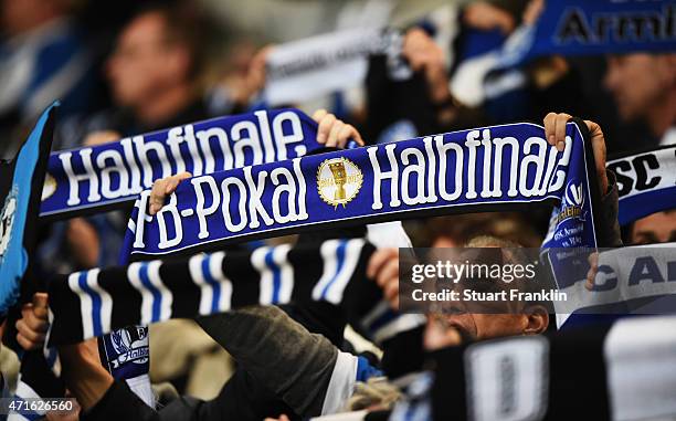 Fans of Bielefeld hold their semi final scarves during the DFB Cup semi final match between Arminia Bielefeld and VfL Wolfsburg at Schueco Arena on...