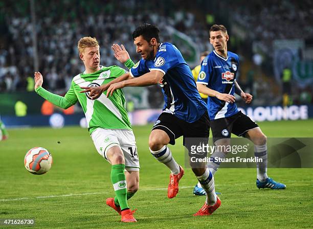 Kevin De Bruyne of Wolfsburg is challenged by Stephan Salger of Bielefeld during the DFB Cup semi final match between Arminia Bielefeld and VfL...