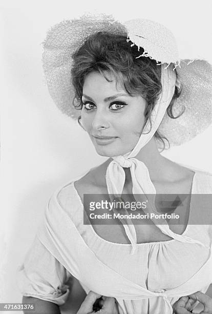 Italian actress Sophia Loren as Cathrine Hubscher wearing a straw hat on the set of the film Madame. 1961