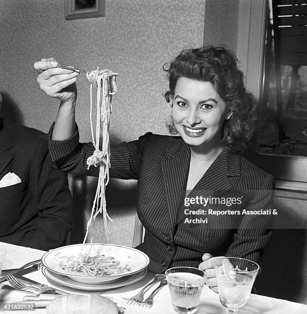 Italian actress Sophia Loren eating spaghetti in a restaurant. Italy, 1953